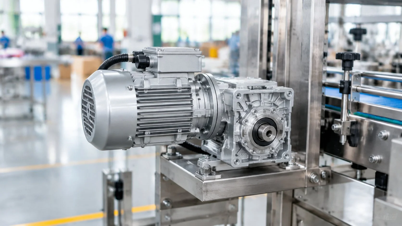 Silver AC gear motor with parallel-shaft gearbox driving a packaging machine in a clean factory workshop